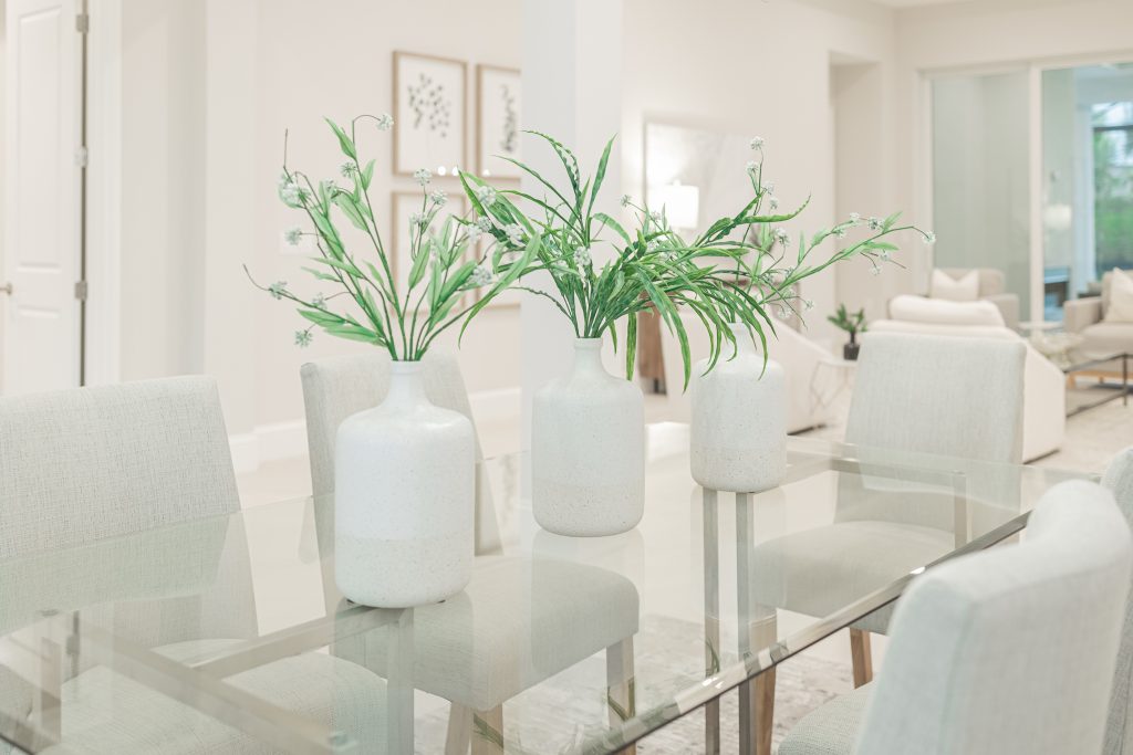 Luxurious, neutrally-toned kitchen featuring marble countertops, sleek cabinetry, and vibrant greenery for an elegant, inviting atmosphere.