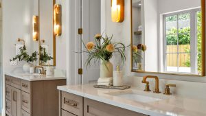 Home Staged in Central Florida by Step By Stage Interiors featuring a bathroom with marble countertops, elegant houseplants, and wooden cabinets