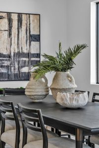 Luxury kitchen staged in the Tampa area featuring modern artwork and centerpieces on a wooden table